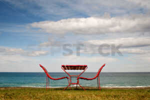 A red table and chairs at the beach, Napier, Hawke’s Bay, New Zealand - SCP Stock