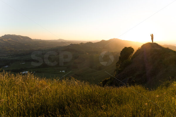 A tourist photographing the landscape at sunset, Te Mata Peak, Havelock North, New Zealand - SCP Stock