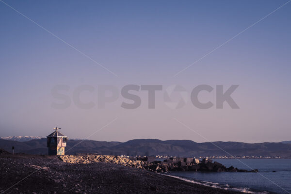 A winter morning looking towards Perfume Point lighthouse and thesnow capped Kaweka Ranges at the Perfume Point Reserve beach, Ahuriri, Napier, Hawke’s Bay, New Zealand - SCP Stock