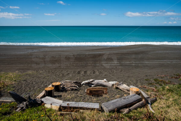 Beach fire pit and driftwood seats, Hawke’s Bay, New Zealand - SCP Stock