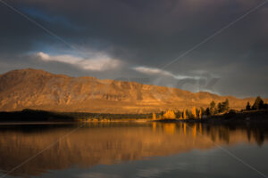 Golden hour at Lake Tekapo in Autumn, with Mount Dobson in the distance, Mackenzie region, South Island, New Zealand - SCP Stock