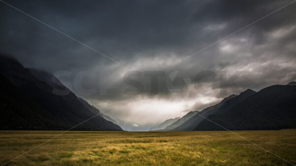 Moody Skies over Yellow Grass, Eglington Valley, Fiordland, New Zealand - SCP Stock