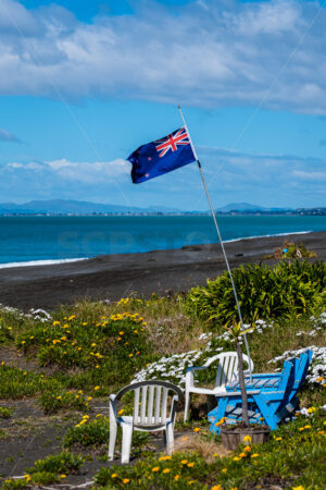 New Zealand Flag and chairs on the beach, Napier, Hawke’s Bay, New Zealand - SCP Stock