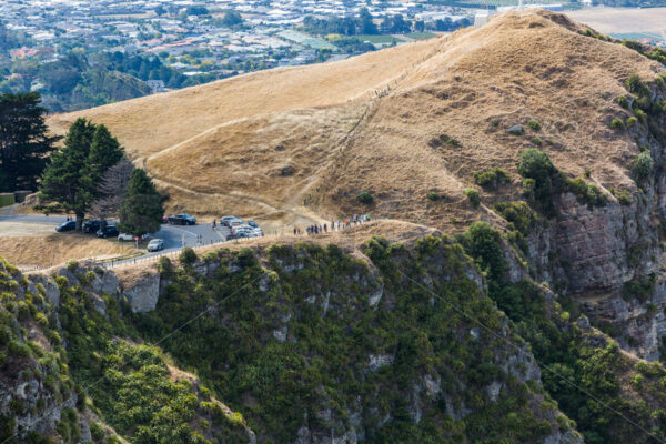 People standing on Te Mata Peak watching a summer grass fire, Hawke’s Bay, New Zealand - SCP Stock