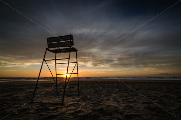 Surf lifesaving chair at sunrise, Ocean Beach, Hawke’s Bay, New Zealand - SCP Stock