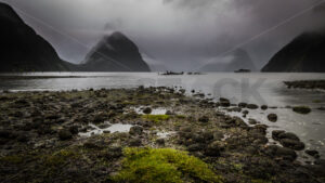 Tourist Boat Under Stormy Skies at Mitre Peak, Milford Sound, Fiordland, New Zealand - SCP Stock