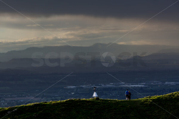 Two people standing on a Te Mata Peak ridgeline looking out over Hastings, Hawke’s Bay, New Zealand - SCP Stock