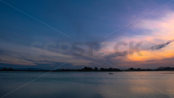 A small boat on the river at sunset, Hawke’s Bay, New Zealand - SCP Stock