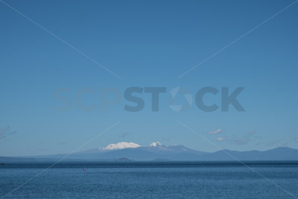 The view over Lake Taupo view towards Mount Ngauruhoe & Ruapehu from Taupo, Waikato, New Zealand - SCP Stock