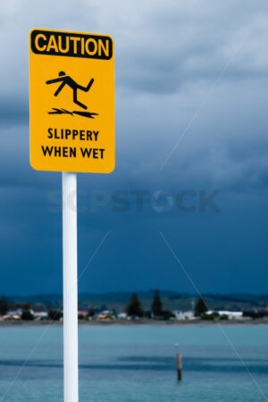 CAUTION, Slippery When Wet signage, Ahuriri, Napier, Hawke’s Bay, New Zealand - SCP Stock