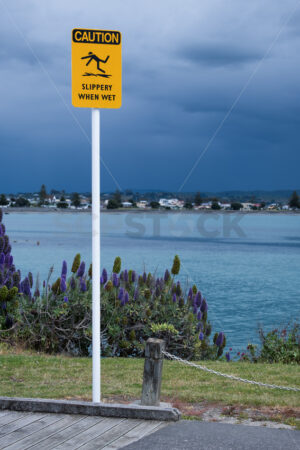 CAUTION, Slippery When Wet signage, Ahuriri, Napier, Hawke’s Bay, New Zealand - SCP Stock