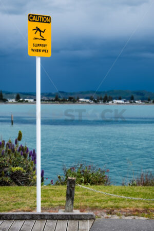 CAUTION, Slippery When Wet signage, Ahuriri, Napier, Hawke’s Bay, New Zealand - SCP Stock