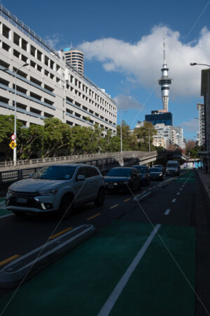 Traffic on Lower Hobson Street with the Skytower behind, Auckland CBD, New Zealand - SCP Stock