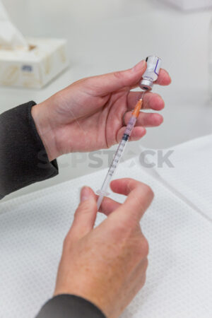 Doctor / Nurse drawing a vaccination syringe - SCP Stock